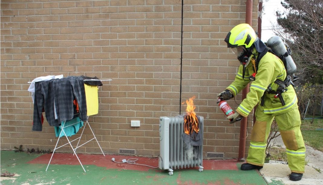 ACT Fire & Rescue’s Martin Genge extinguishes a heater fire. Photo: Nick Fuller
