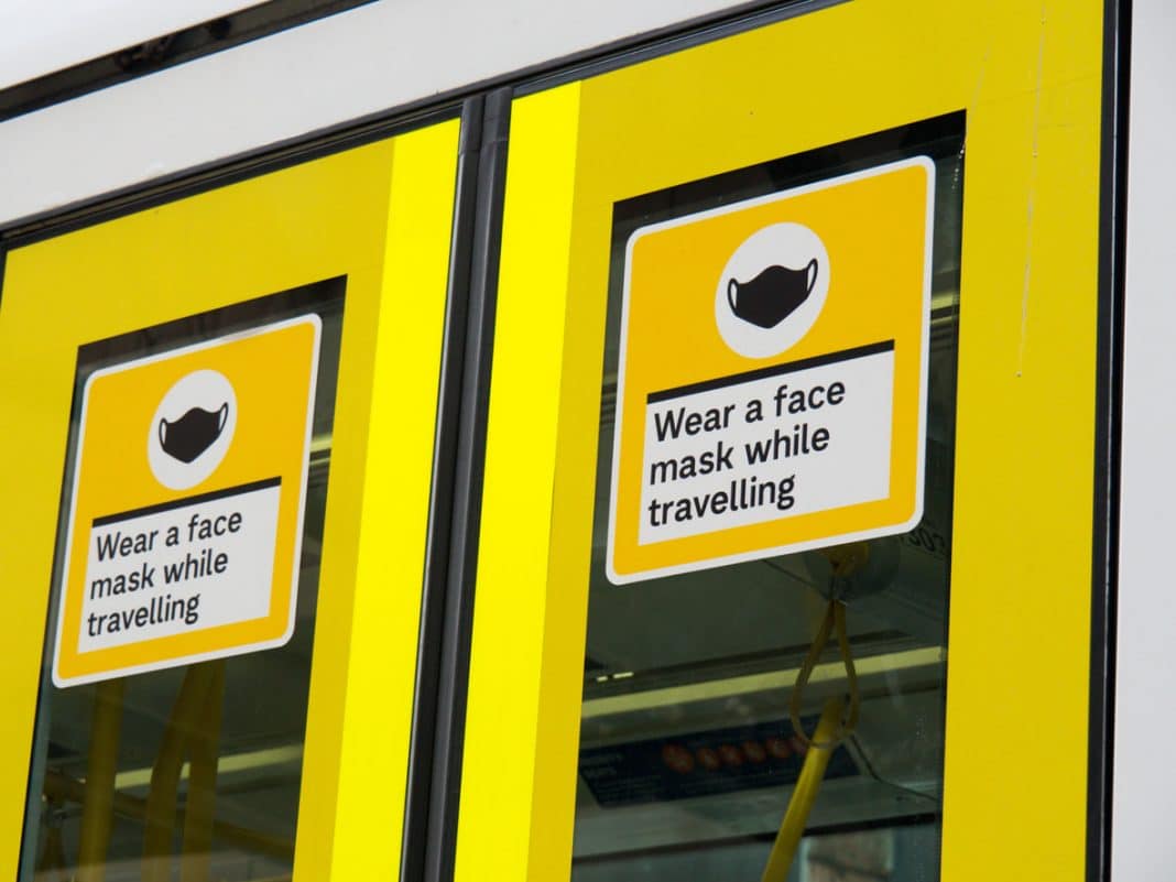 yellow signs in tram that read: wear a face mask while travelling
