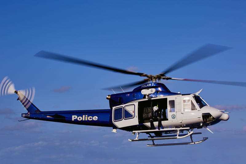 Blue and white police helicopter flying in the sky