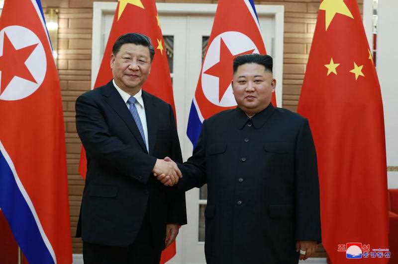 Chinese President Xi Jinping and North Korean leader Kim Jong Un shaking hands
