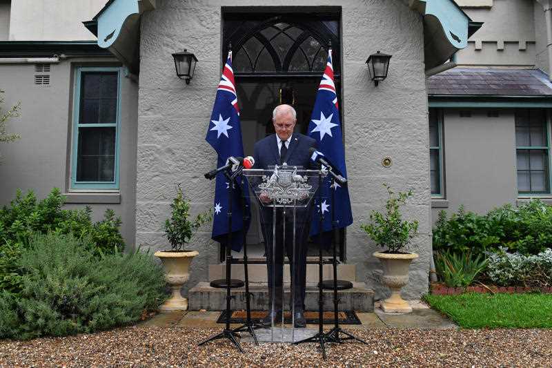 Australian Prime Minister Scott Morrison flanked by two Australian flags outside Kirribilli House in Sydney speaking at a press conference
