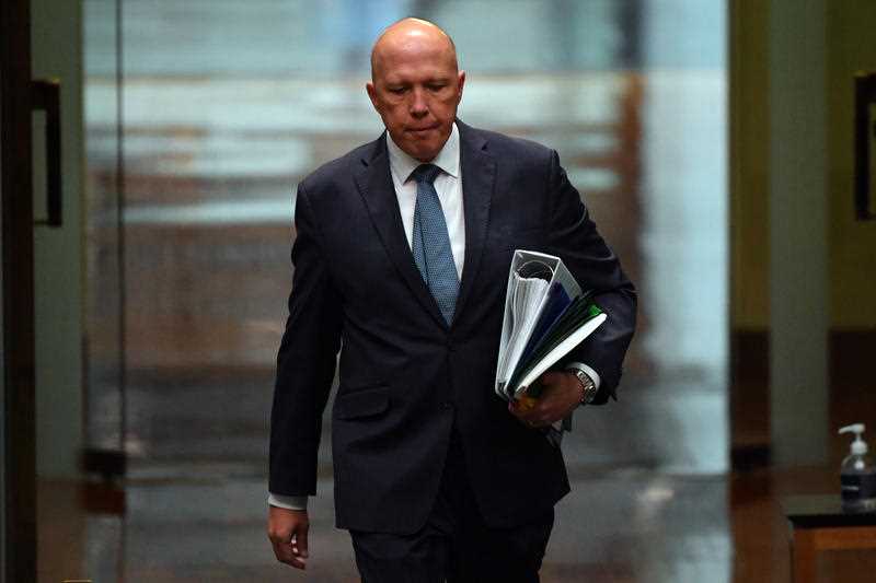 Minister for Defence Peter Dutton walking down a corridor at Australian Parliament House