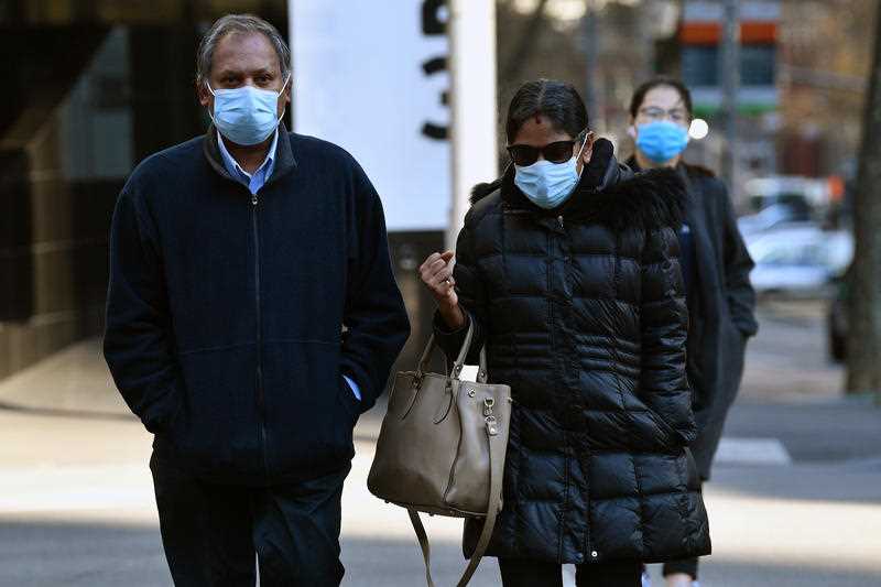 man and woman charged with keeping a Tamil woman as a slave arrive at court wearing face masks