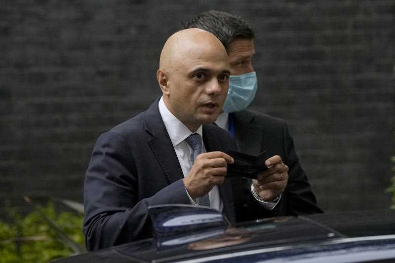 Britain's newly appointed Health Secretary Sajid Javid looks at photographers as he puts on a face mask to curb the spread of coronavirus