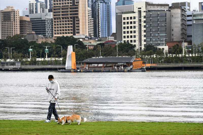 A lone woman walks her dog in Southbank during the last few hours of a lockdown in Brisbane, Saturday, July 3
