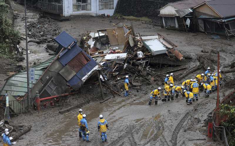Teams of around 20 rescuers sorting through mudslide rubble in Japan