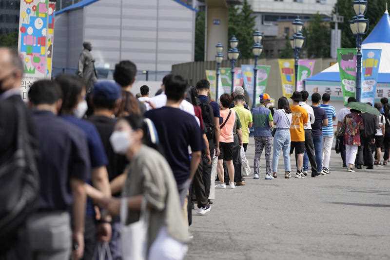 Long queue of people wearing masks outside coronavirus testing site in Seoul, South Korea