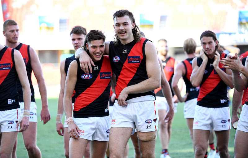 2 Bombers AFL players with arms around one another after a match