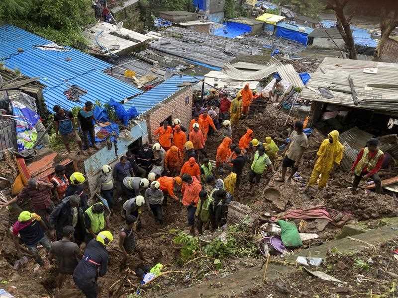 Rescuers look for survivors after a wall collapsed on several slum houses heavy monsoon rains in the Mahul area of Mumbai, India