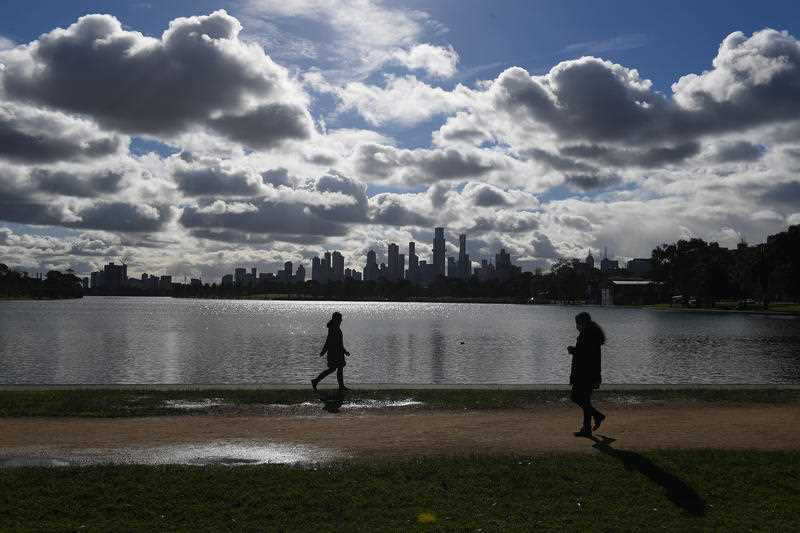 2 People are seen walking around Albert Park Lake in Melbourne