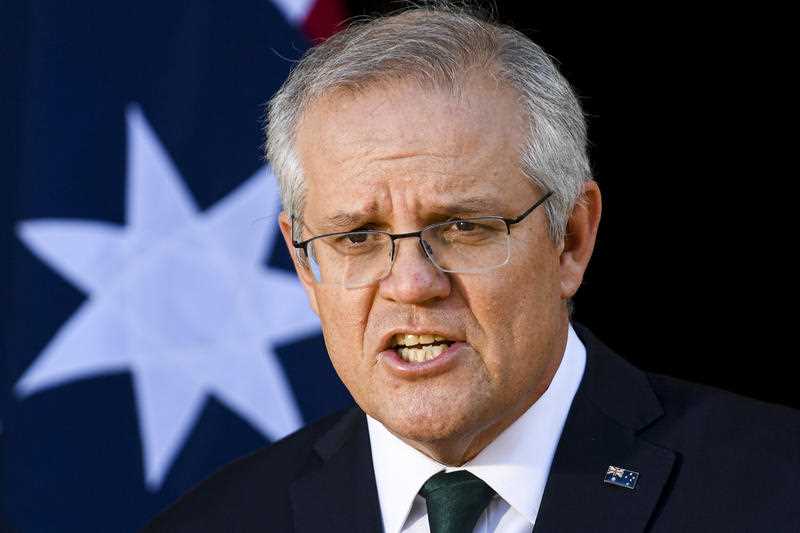 Prime Minister Scott Morrison speaking at a press conference in front of an Australian flag