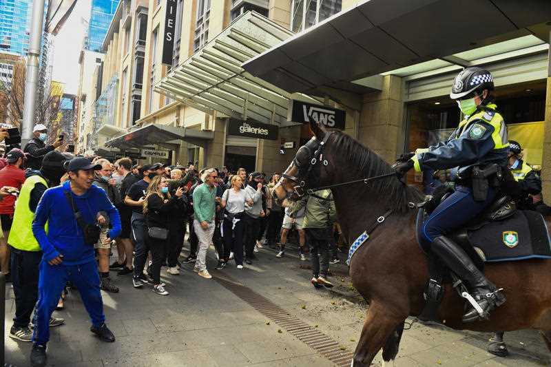 Protesters face off with mounted police at Sydney Town Hall during the ‘World Wide Rally For Freedom’ anti-lockdown rally at Hyde Park in Sydney, Saturday, July 24