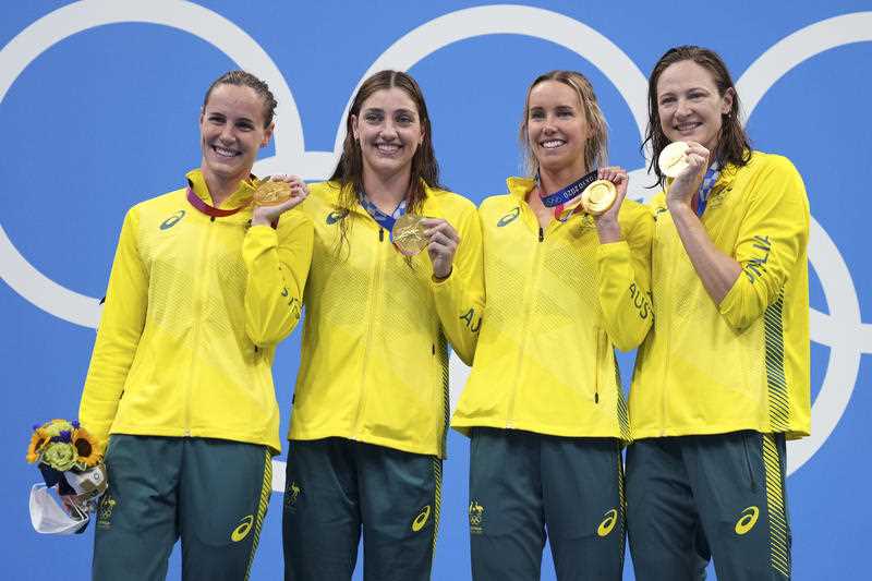 Australia's women's 4x100m women's relay team, Meg Harris, Bronte Campbell, Emma McKeon and Cate Campbell celebrate on the podium at the 2020 Summer Olympics