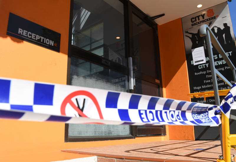 Police tape is seen at the entry to the Roma Street City Backpackers Hostel in Brisbane