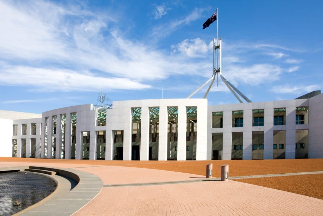 partial facade of Australian Parliament House entrance with flagpole towering above