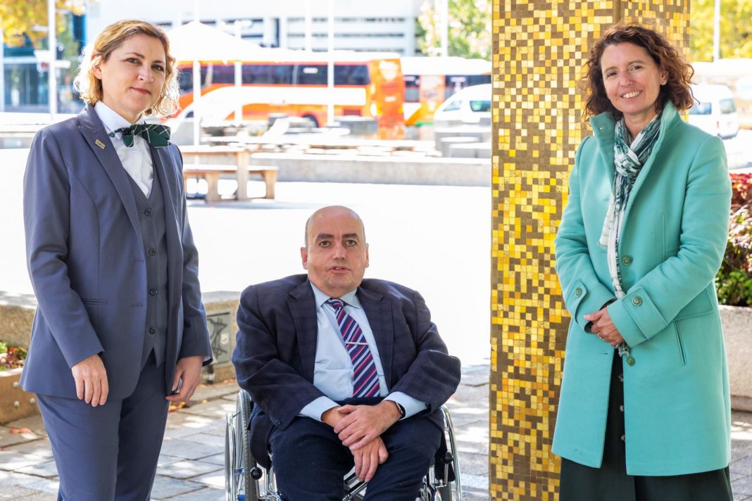 man in wheelchair situated between two female politicians outside the ACT Legislative Assembly