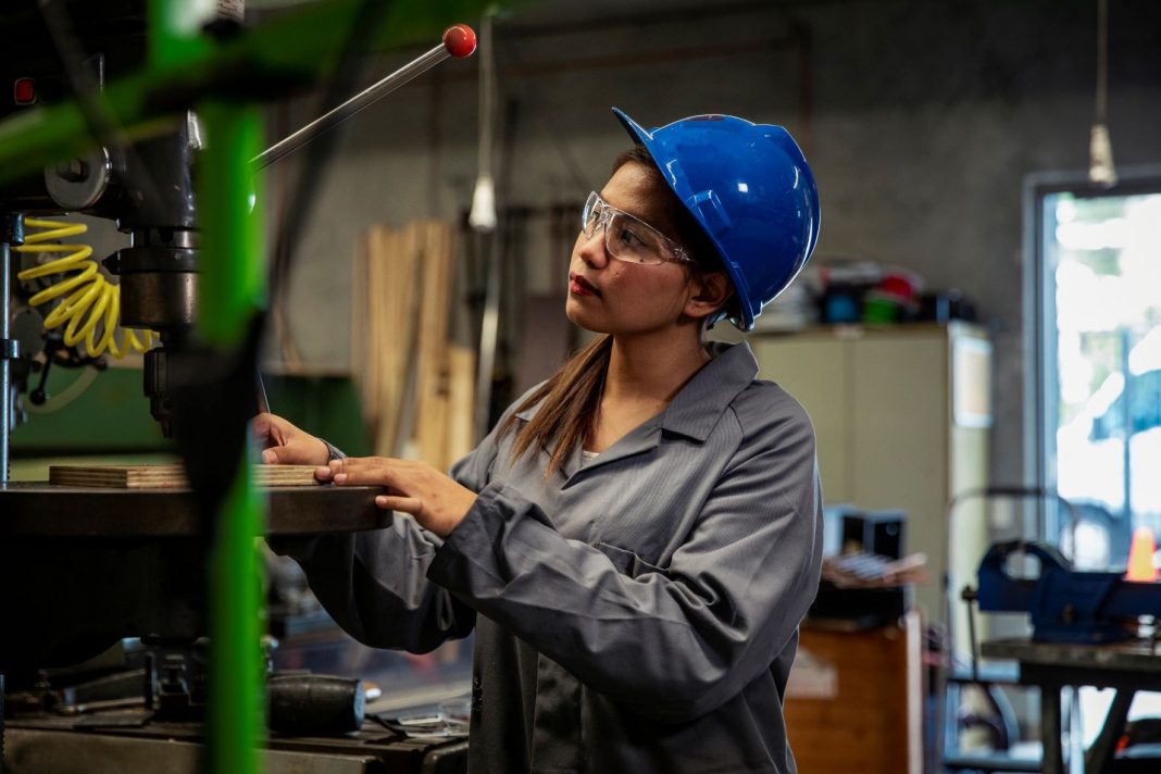 young female tradie wearing hard hat and safety goggles