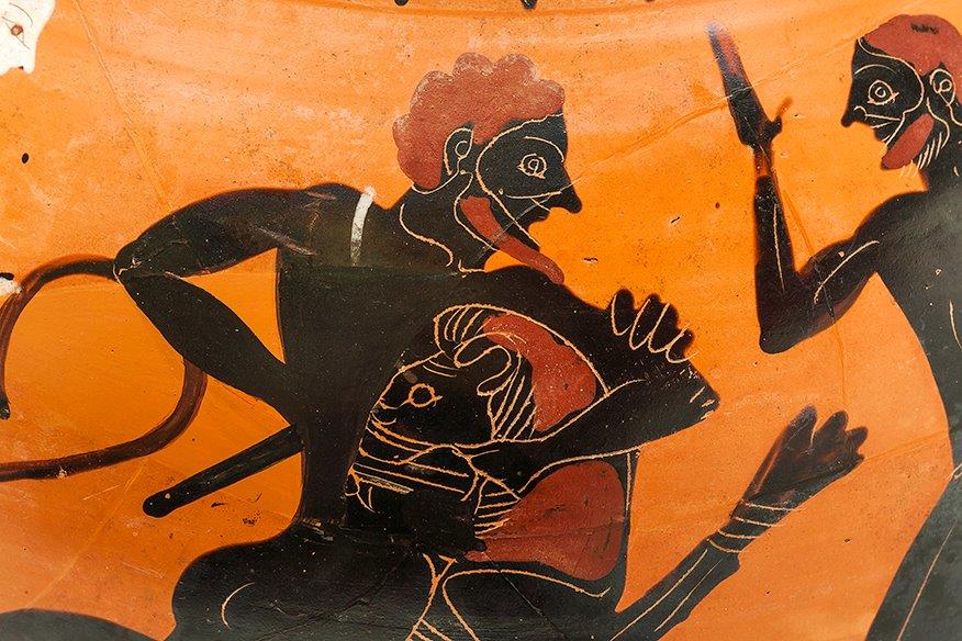Black, ochre and white artwork on an ancient Greek vase depicting a warrior battling a lion