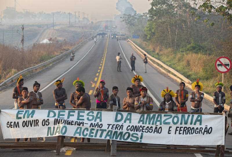Kayapo Indigenous protesters in Brazil block highway BR-163 with a banner that reads in Portuguese 