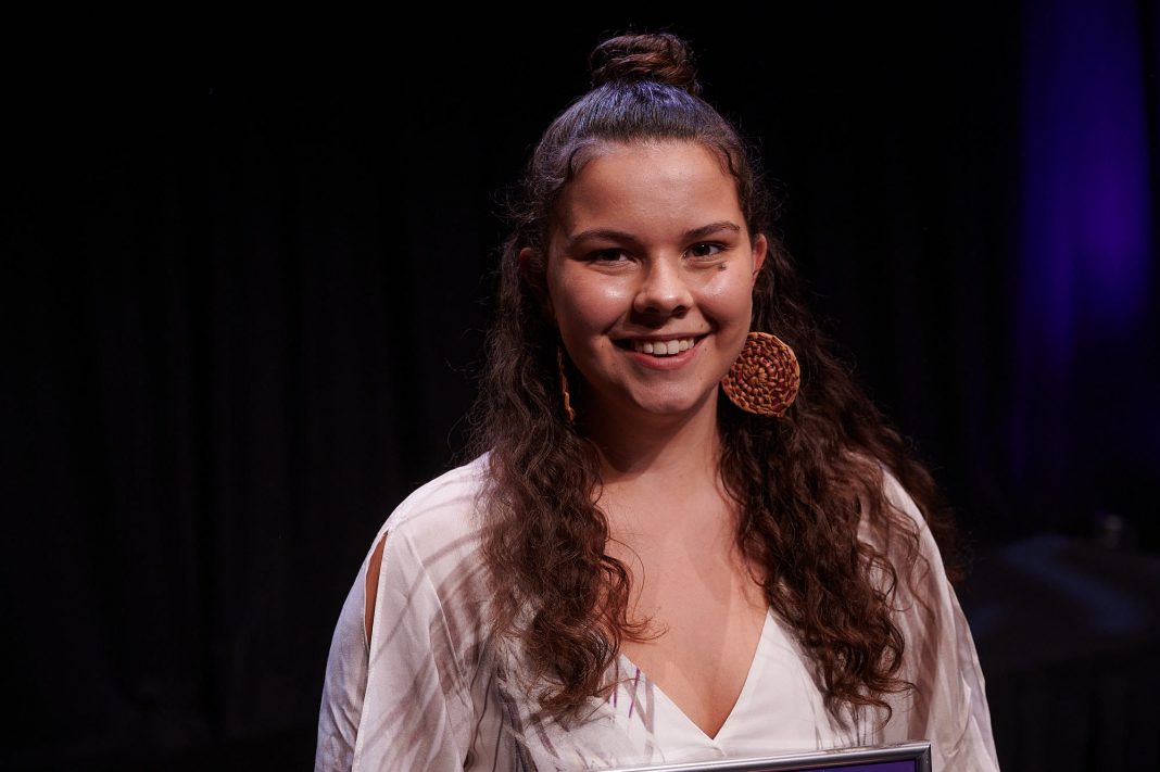 Smiling, beautiful young Indigenous woman accepting an award