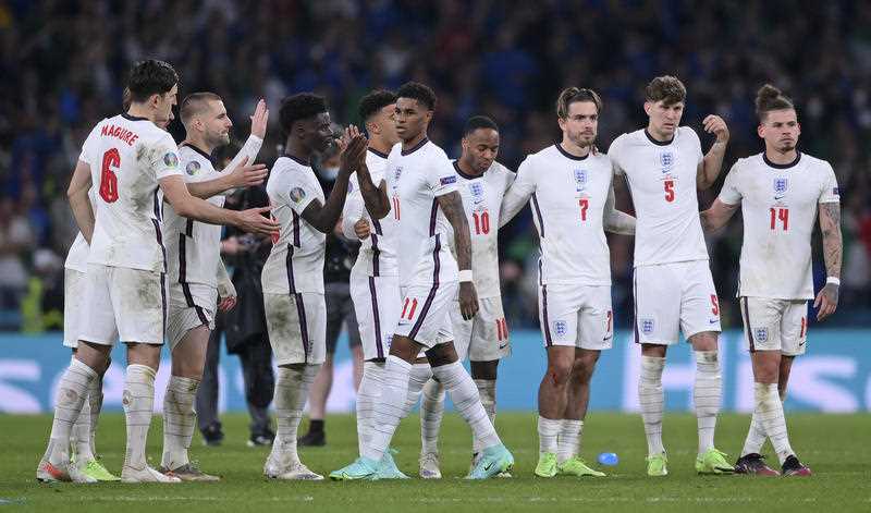 England's Harry Maguire, Luke Shaw and Bukayo Saka, from left, reach out to Marcus Rashford after he missed a penalty in the penalty shootout of the Euro 2020 soccer final match between England and Italy at Wembley stadium in London on 11 July 2021