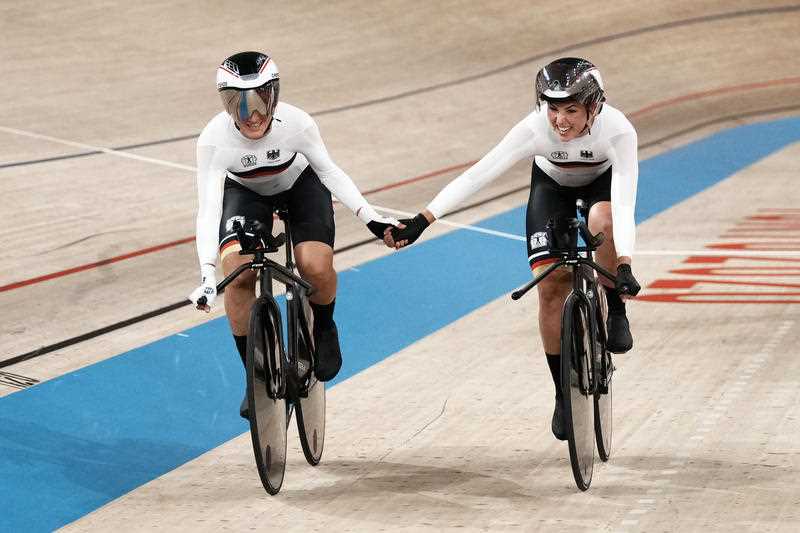 Lisa Brennauer, left, and Lisa Klein of Team Germany celebrate a world record as they win gold the track cycling women's team pursuit at the 2020 Summer Olympics