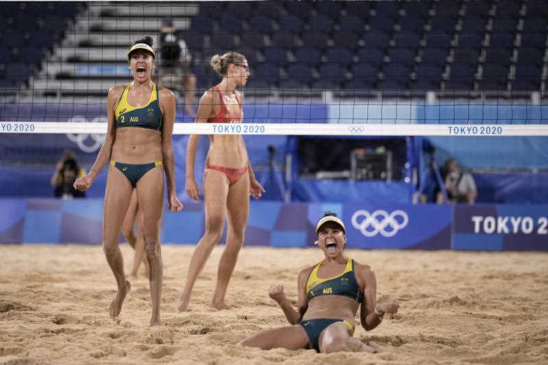Two Australian female beach volleyball players celebrate after winning a quarterfinal match against Canada