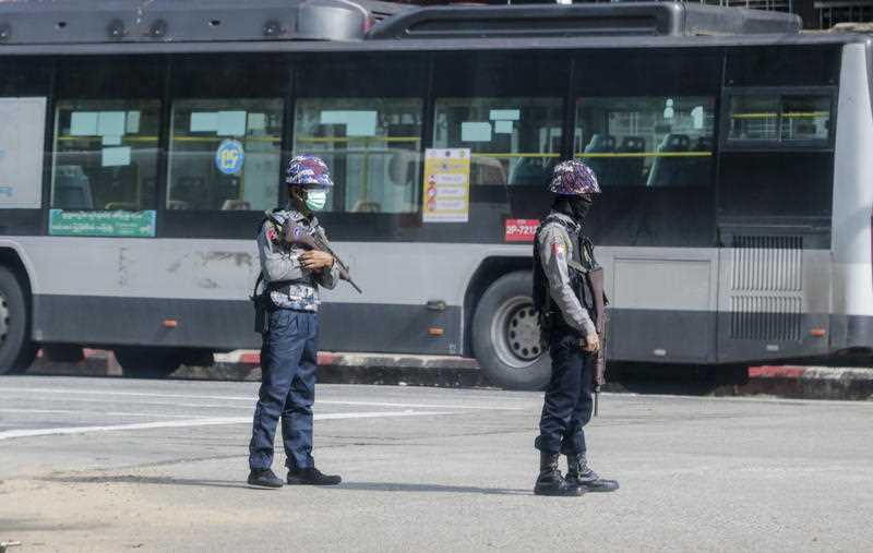 Armed policemen stand guard as they block a road after several explosions occurred at downtown area in Yangon, Myanmar