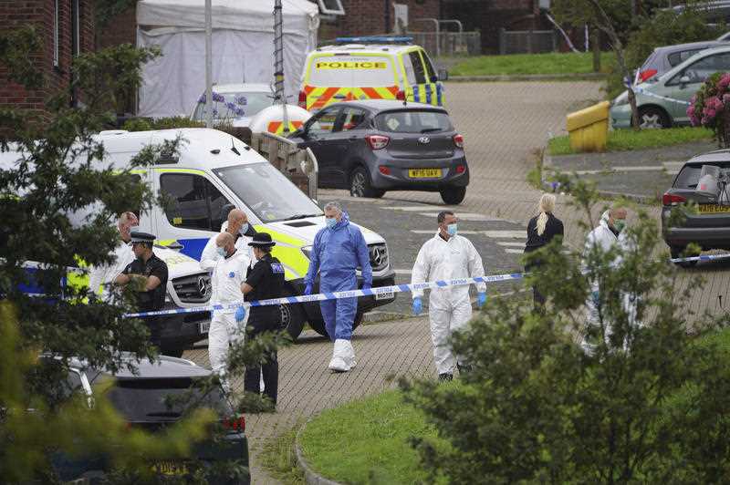 Forensic officers walk in Biddick Drive in the Keyham area of Plymouth, England Friday Aug. 13, 2021 where six people were killed in a shooting incident.