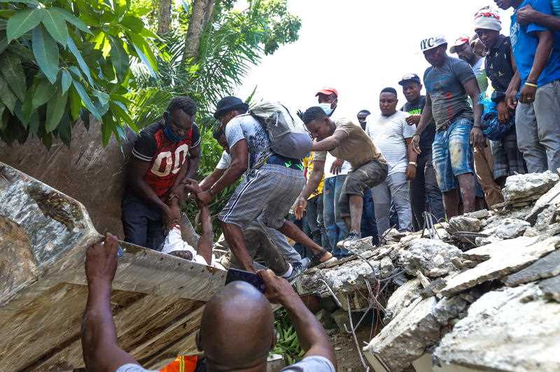 Groups of people carry out searches for survivors after a 7.2 magnitude earthquake, in Los Cayos, Haiti, 14 August 2021.