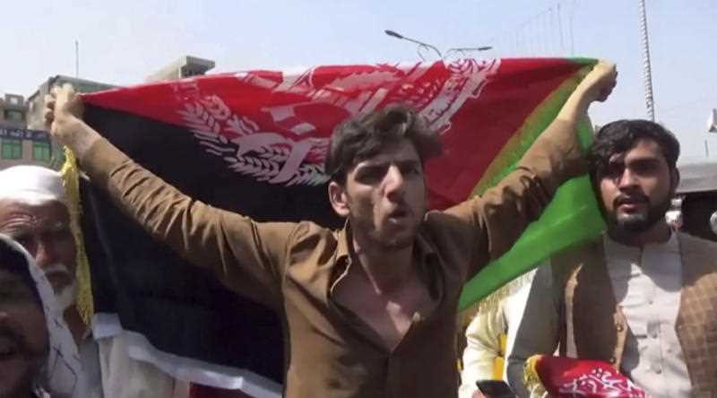 A man holds the flag of Afghanistan during an anti-Taliban protest in Jalalabad on Wednesday, Aug. 18, 2021