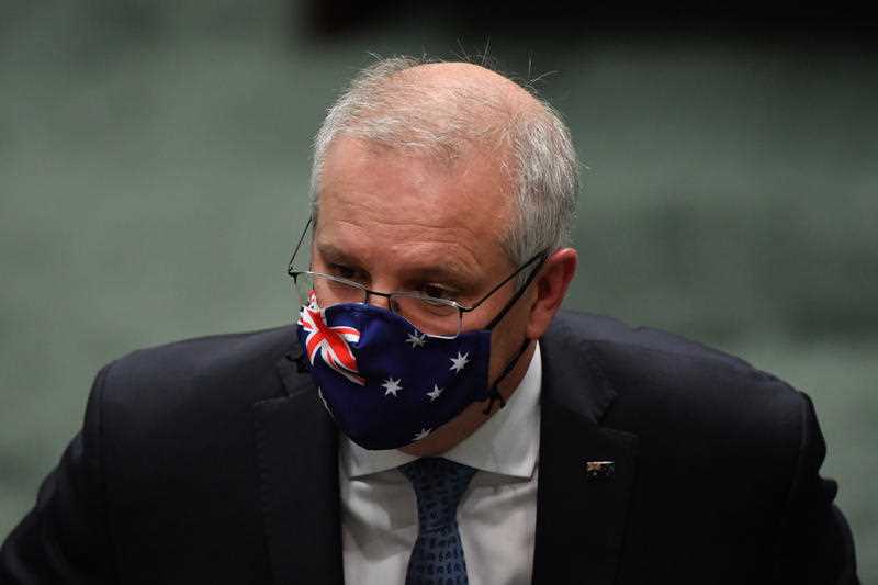 Prime Minister Scott Morrison wearing an Australian flag face mask leaves after Question Time in the House of Representatives at Parliament House in Canberra, Monday, August 23, 2021.