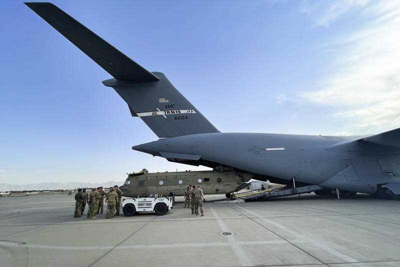 a CH-47 Chinook from the 82nd Combat Aviation Brigade, 82nd Airborne Division is loaded onto a U.S. Air Force C-17 Globemaster III at Hamid Karzai International Airport in Kabul, Afghanistan