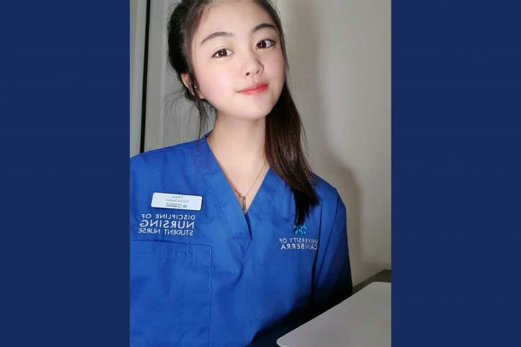 young female nursing student in blue scrubs