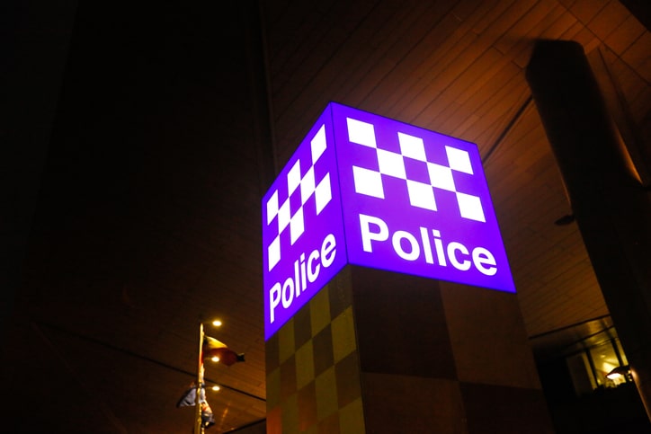 Police station sign lights up the night sky