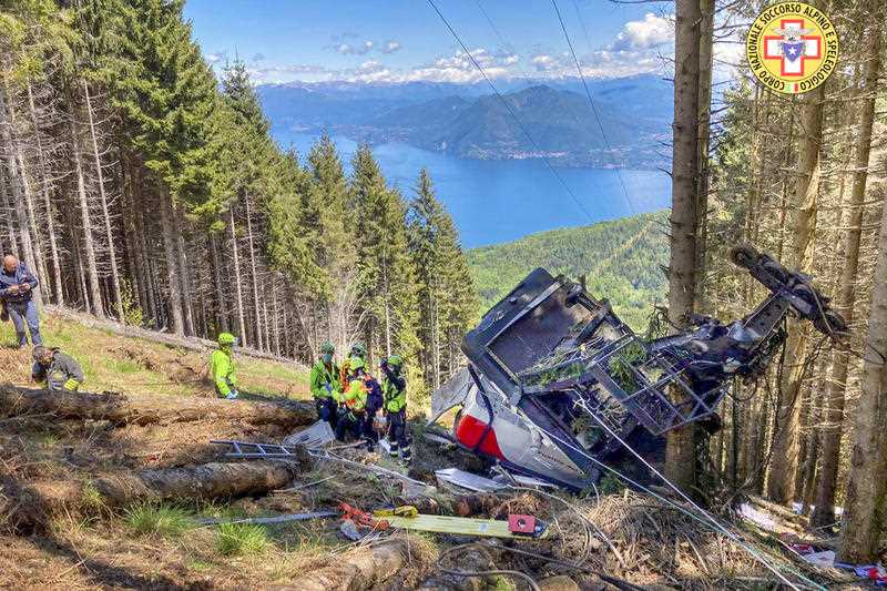 Rescuers work by the wreckage of a cable car after it collapsed near the summit of the Stresa-Mottarone line in the Piedmont region, northern Italy, Sunday, May 23, 2021