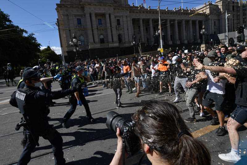 Protesters are pepper sprayed by police during an anti-lockdown protest in the central business district of Melbourne, Saturday, August 21, 2021.