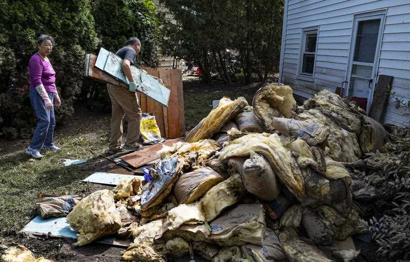 Two residents in New Jersey remove debris from Hurricane Ida from their yard