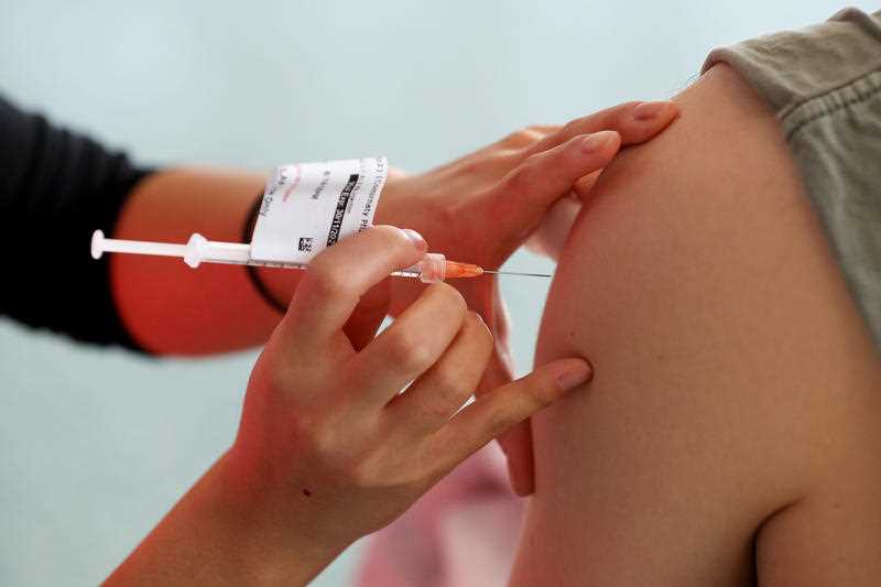 A nurse administers a person with Pfizer COVID-19 vaccine