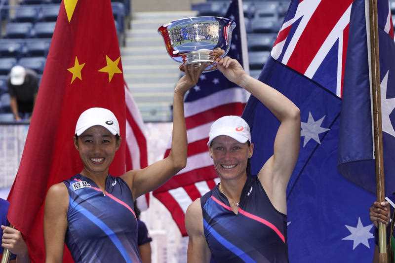 Shual Zhang, of China, left, and Samatha Stosur, of Australia, hold the championship trophy after defeating Coco Gauff and Catherine McNally, both of the United States, during the women's doubles final at the US Open tennis championships