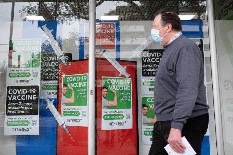 An older man walks past a pharmacy offering COVID-19 vaccinations during lockdown in Canberra, Wednesday, September 29, 2021.