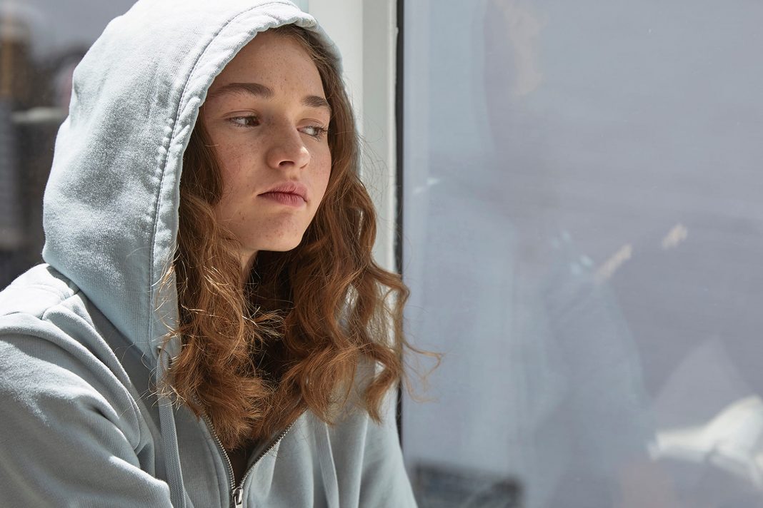 teenage female in hoodie looking thoughtful