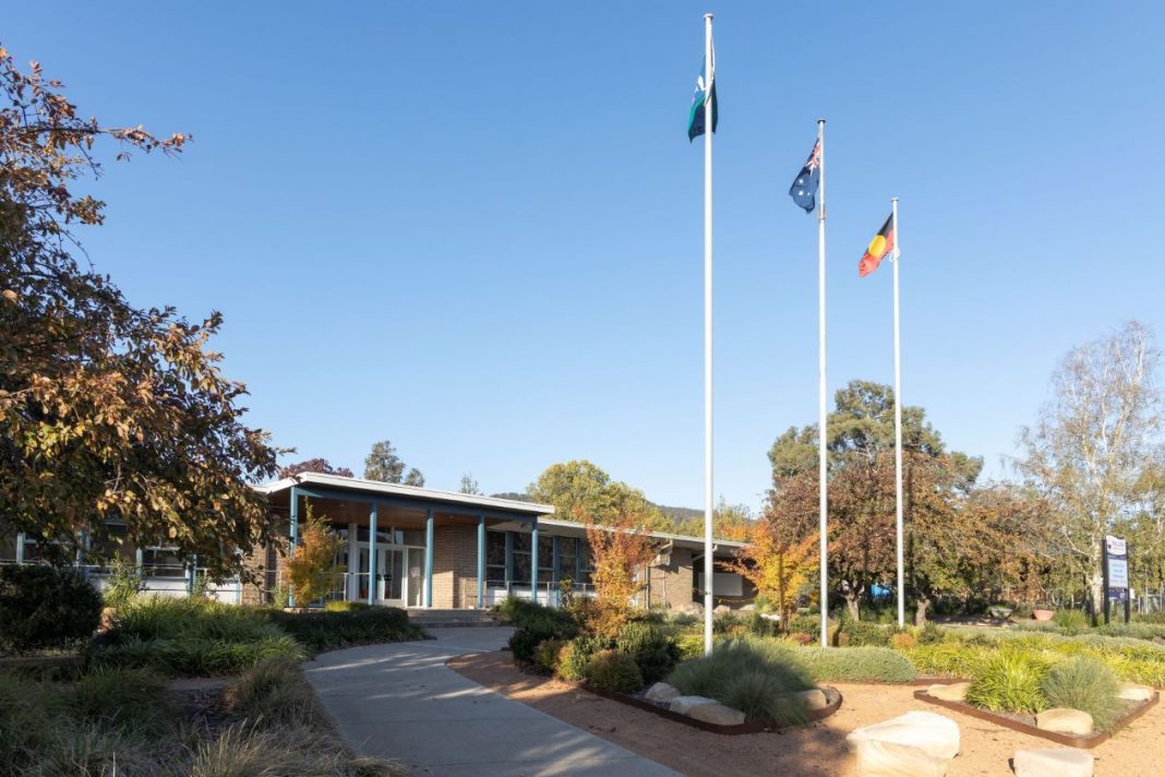 single level primary school in Canberra with 3 flags flying out front
