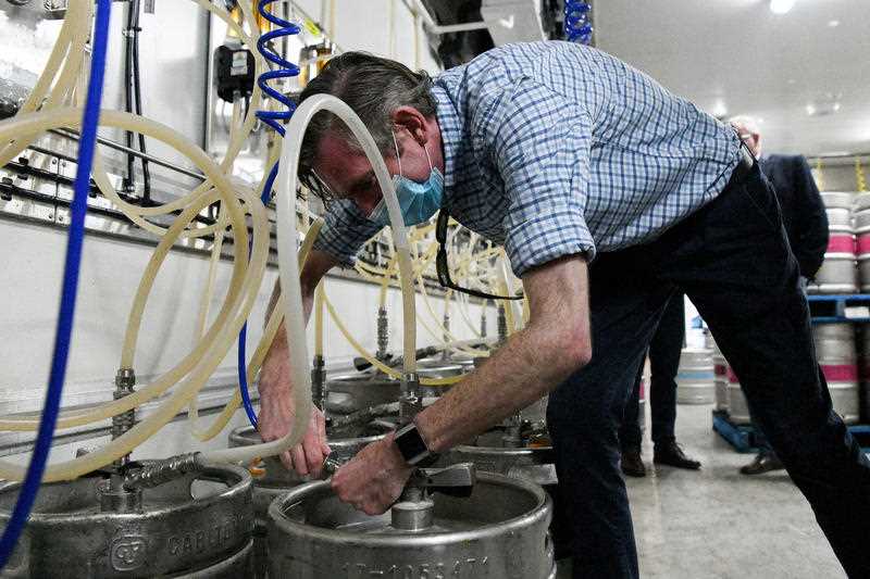 NSW Premier Dominic Perrottet taps a beer keg during a tour of the Marsden Brewhouse in Marsden Park, Sydney, Sunday, October 10, 2021