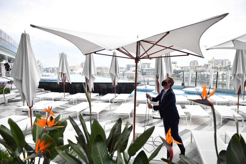 Workers begin reopening preparation by setting up pool umbrellas at Crown Sydney in Sydney, Sunday, October 10, 2021. From Monday, lockdown restrictions will lift for fully vaccinated people across NSW.
