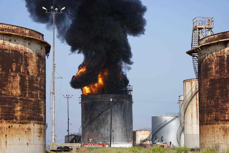 Firefighters work to extinguish a fire in an oil facility in the southern town of Zahrani, south of the port city of Sidon, Lebanon, Monday, Oct. 11, 2021
