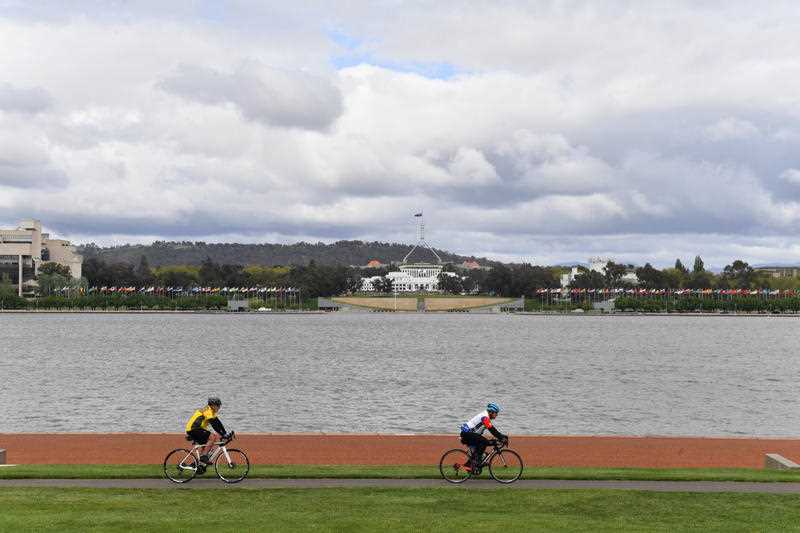 Two cyclists ride through Commonwealth Park on the first day of easing of COVID restrictions in Canberra, Friday, October 15, 2021.
