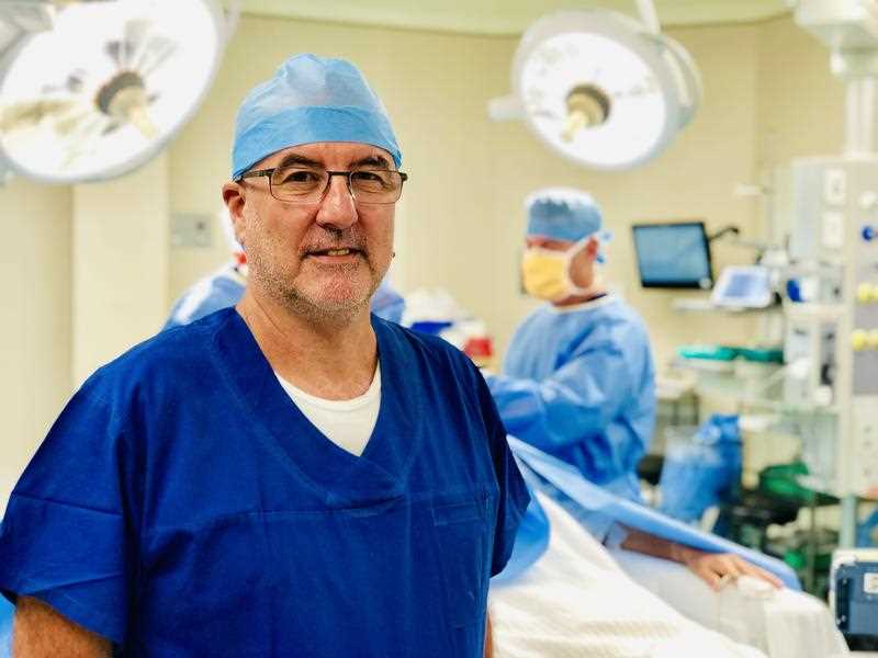 Professor Peter Silburn poses for a portrait inside an operating theatre in Brisbane