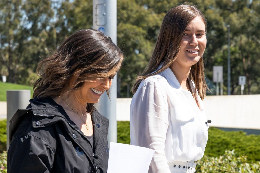 TV presenter Lisa Wilkinson walks with women's safety advocate Brittany Higgins outside Australian parliament house
