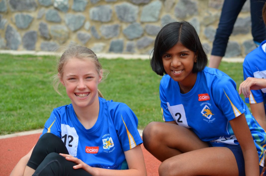 Two young teen girls in Little Athletics ACT gear